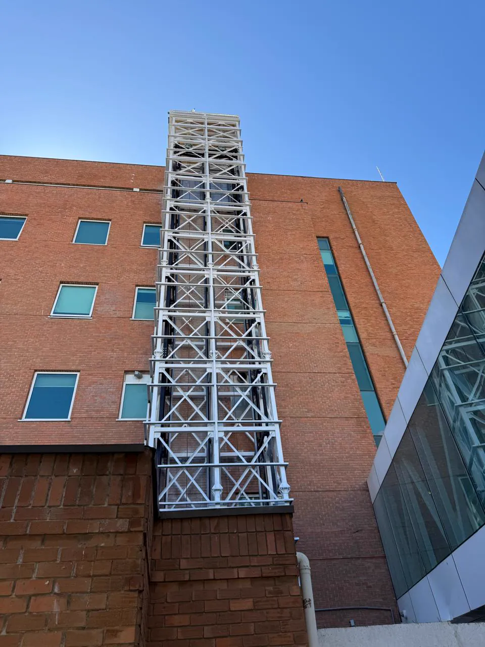 Estructura metálica blanca de varios niveles montada sobre la fachada de un edificio